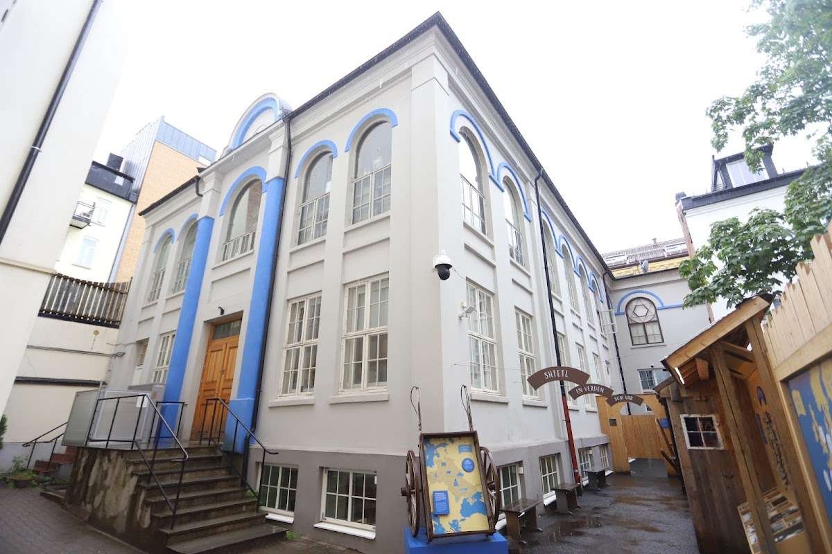 The Jewish Museum in Oslo building with distinctive arched windows and bright blue facade accents.