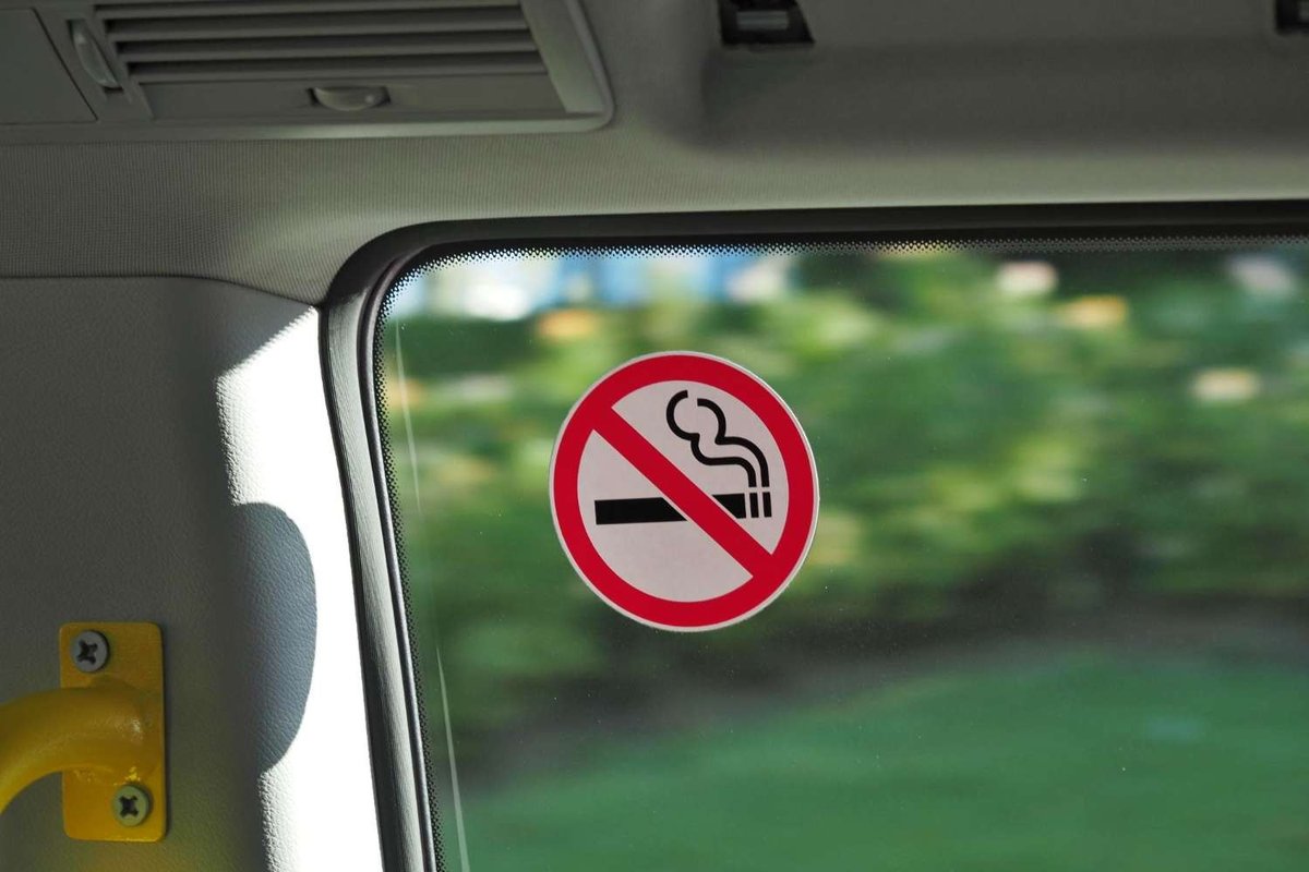 A "No Smoking" sticker on the window of public transport.