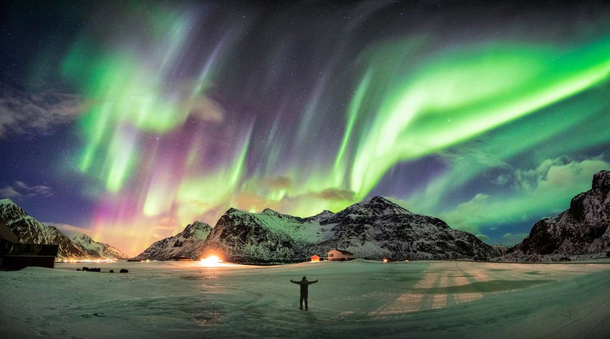 Northern lights in a snowy mountainous area in northern Norway.