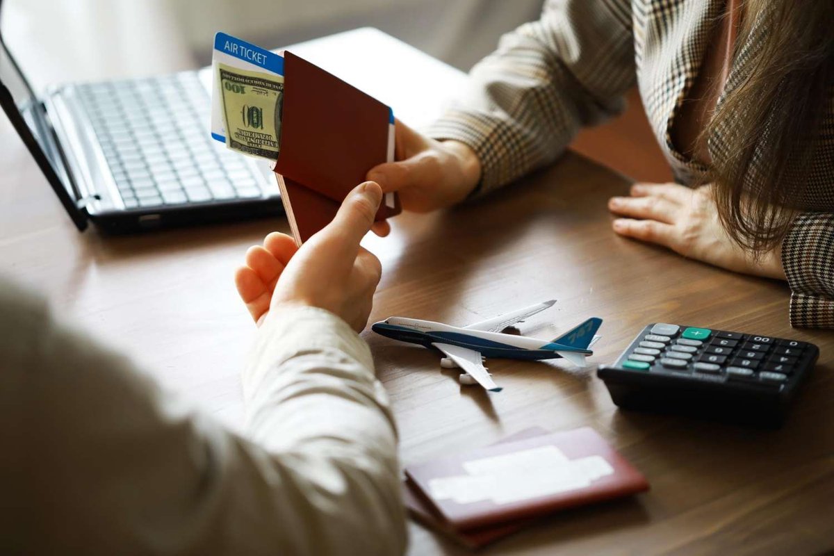Handing over a passport with a flight ticket and banknote in an office.