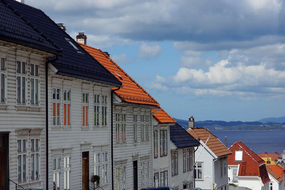 A row of traditional Norwegian houses overlooking a fjord used as residential or rental housing.