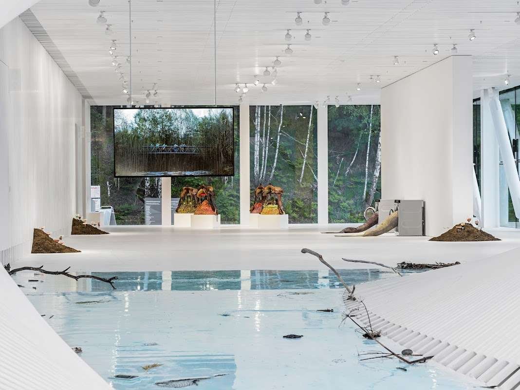 The Twist&#x27;s modern exhibition hall with panoramic windows, Scandinavian design, and art installations set in a natural landscape.