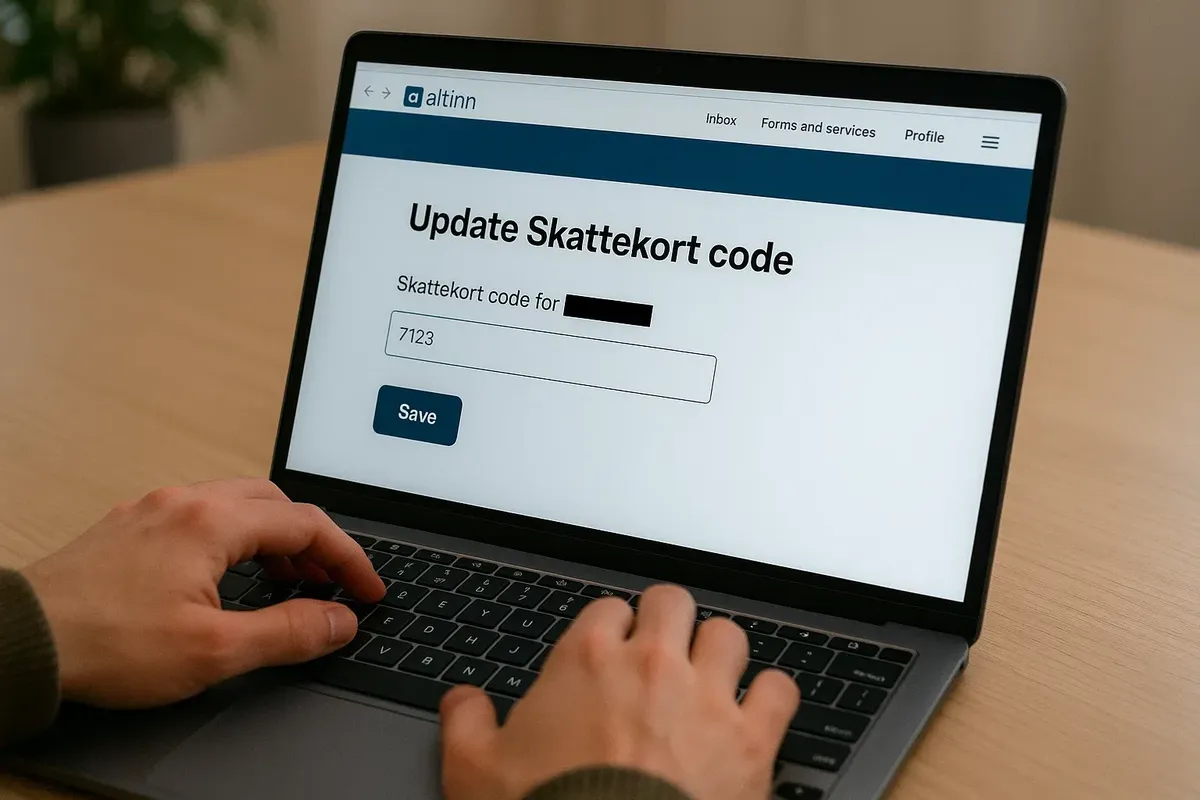 A person sitting at a desk with a laptop open to the Altinn portal, editing their Norwegian Skattekort details.