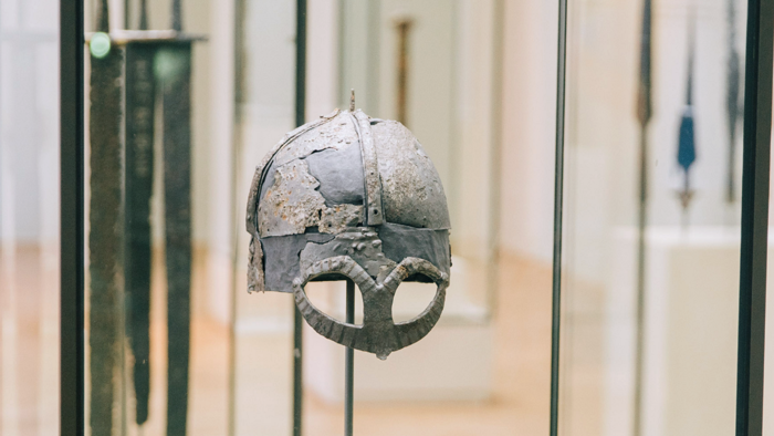 Ancient Viking helmet from Hermundbü, displayed in a Norwegian museum exhibition.